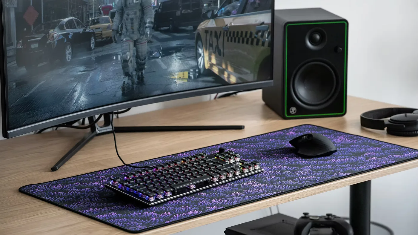 Tapis de bureau PINEA 90 × 40 cm posé sur un bureau, sous un clavier et une souris